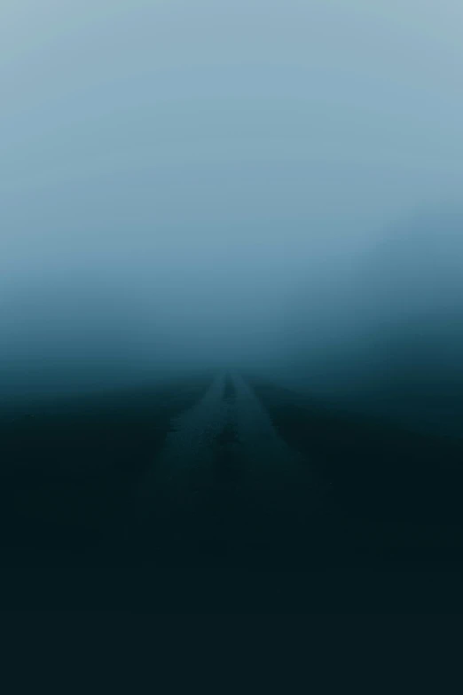 two empty roads going in a very foggy area