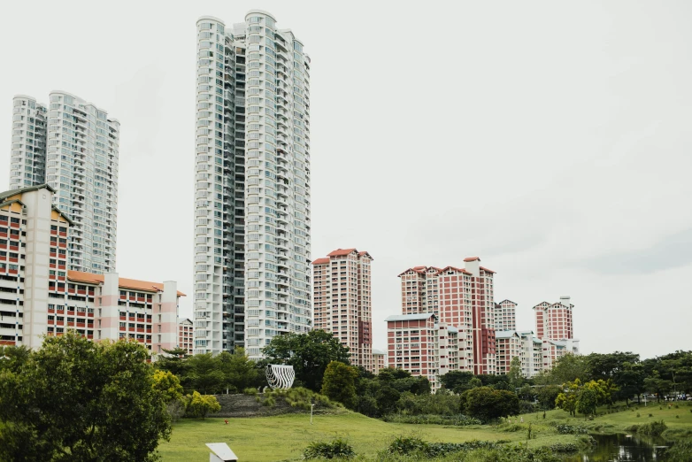 tall buildings next to an artificial lake and park area