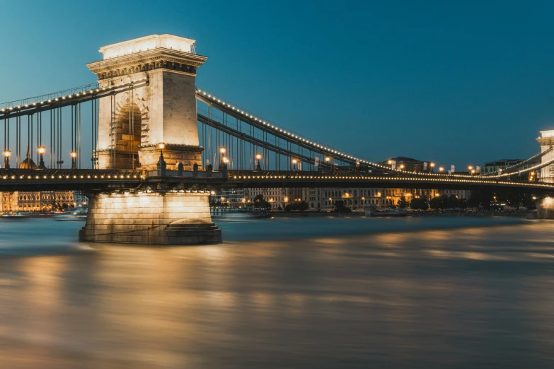 a large long bridge is lit up at night