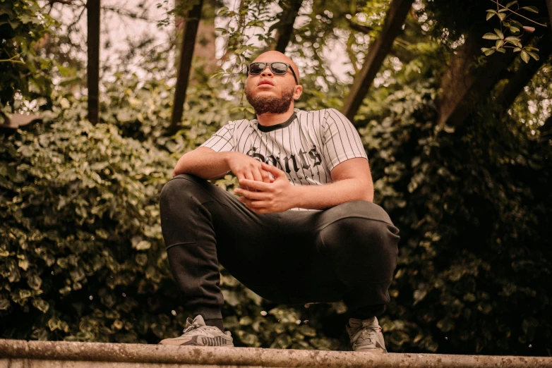 a man sitting on a ledge in the woods