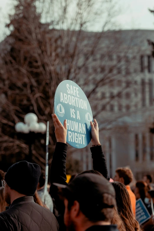 people are standing on the street holding signs