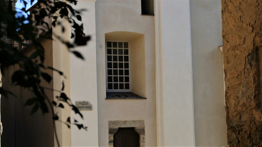 an old white building has a window and small door