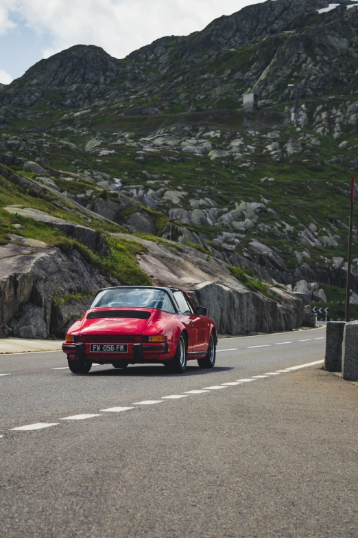 red porsche sports car driving down an open road