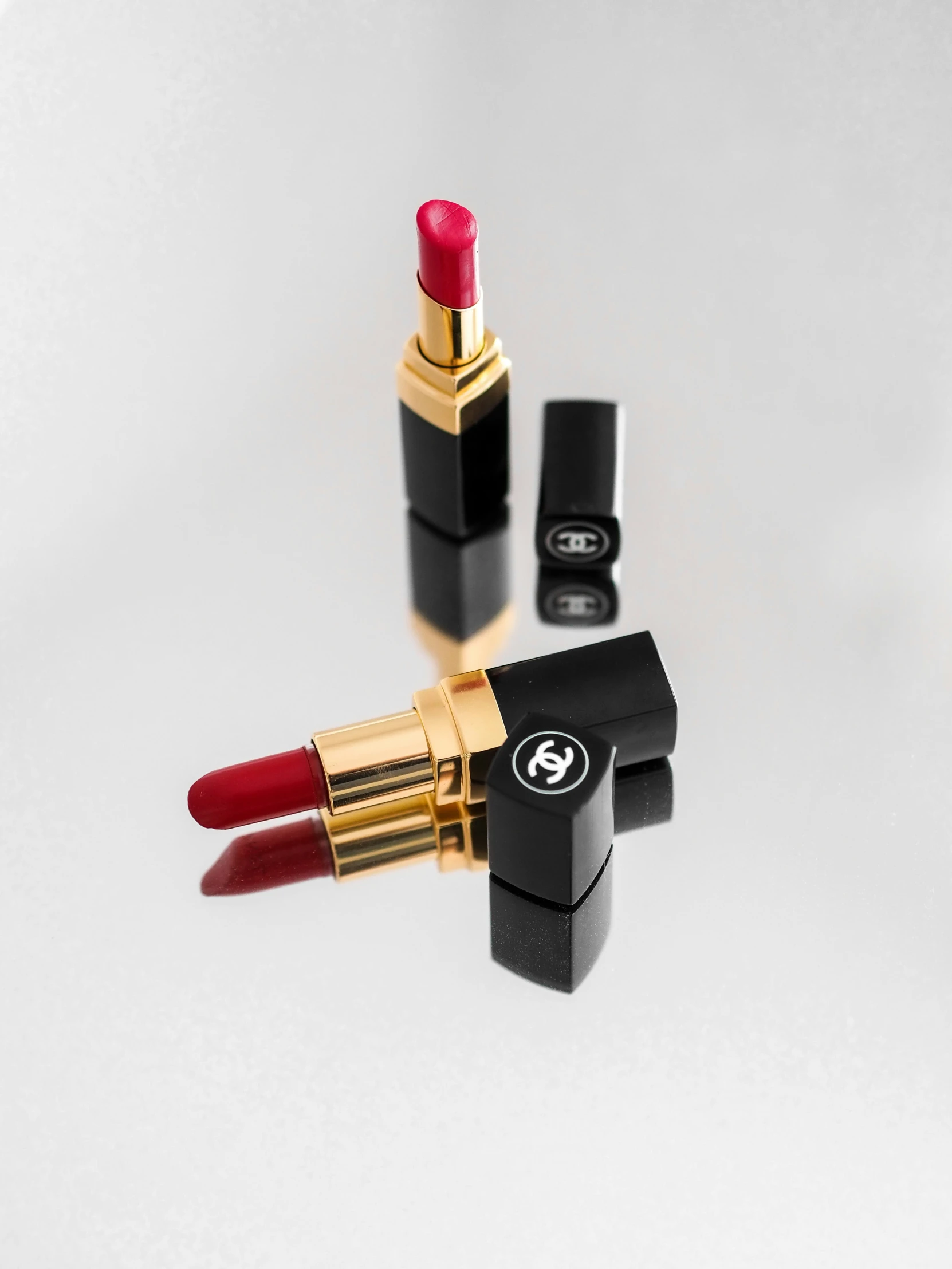 a chanel lipstick is sitting on a reflective surface