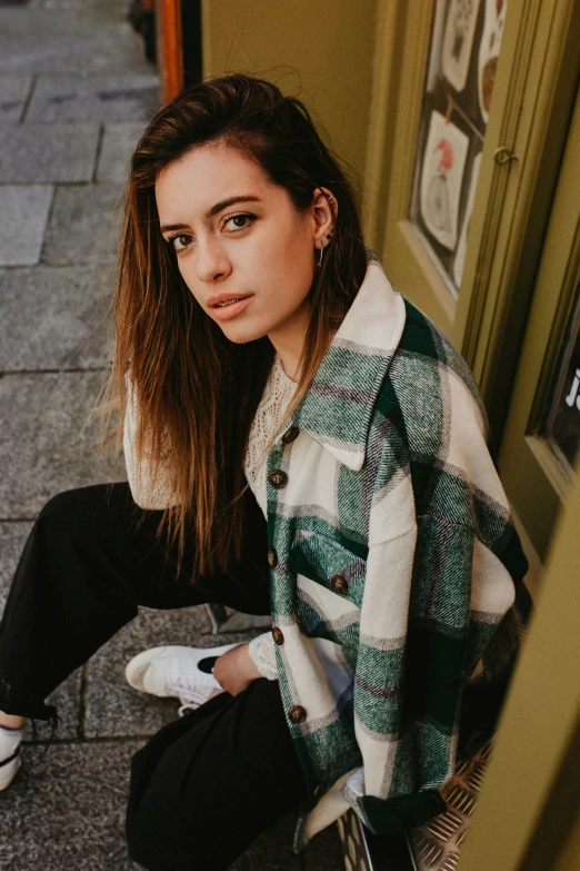 a girl poses while sitting down on the ground