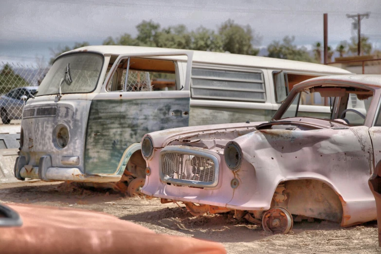 an old truck and a van on dirt ground