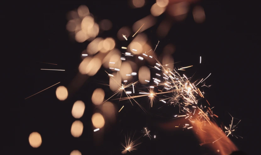 sparklers against the dark night sky are blurred