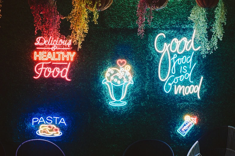 a wall that has different types of neon signs on it