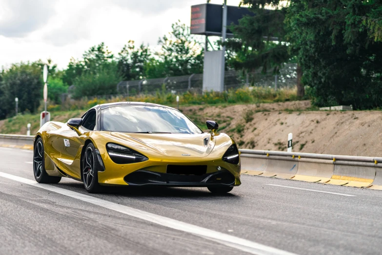 a yellow sports car driving on a paved highway