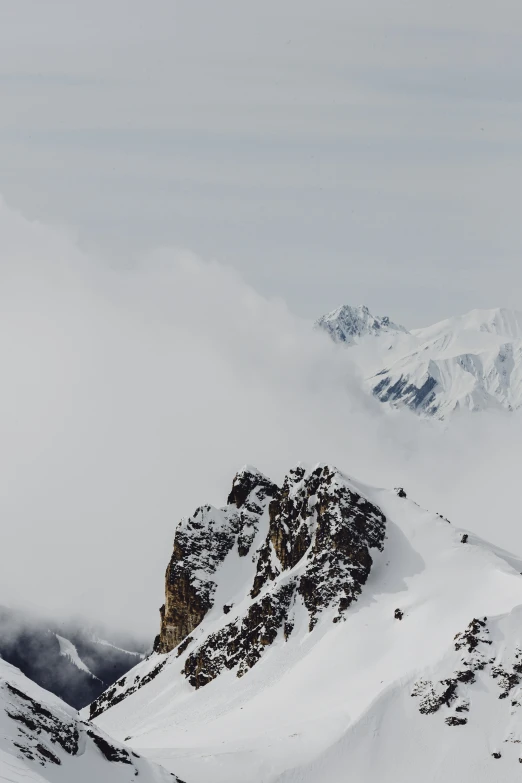 a view of a mountain side with low clouds