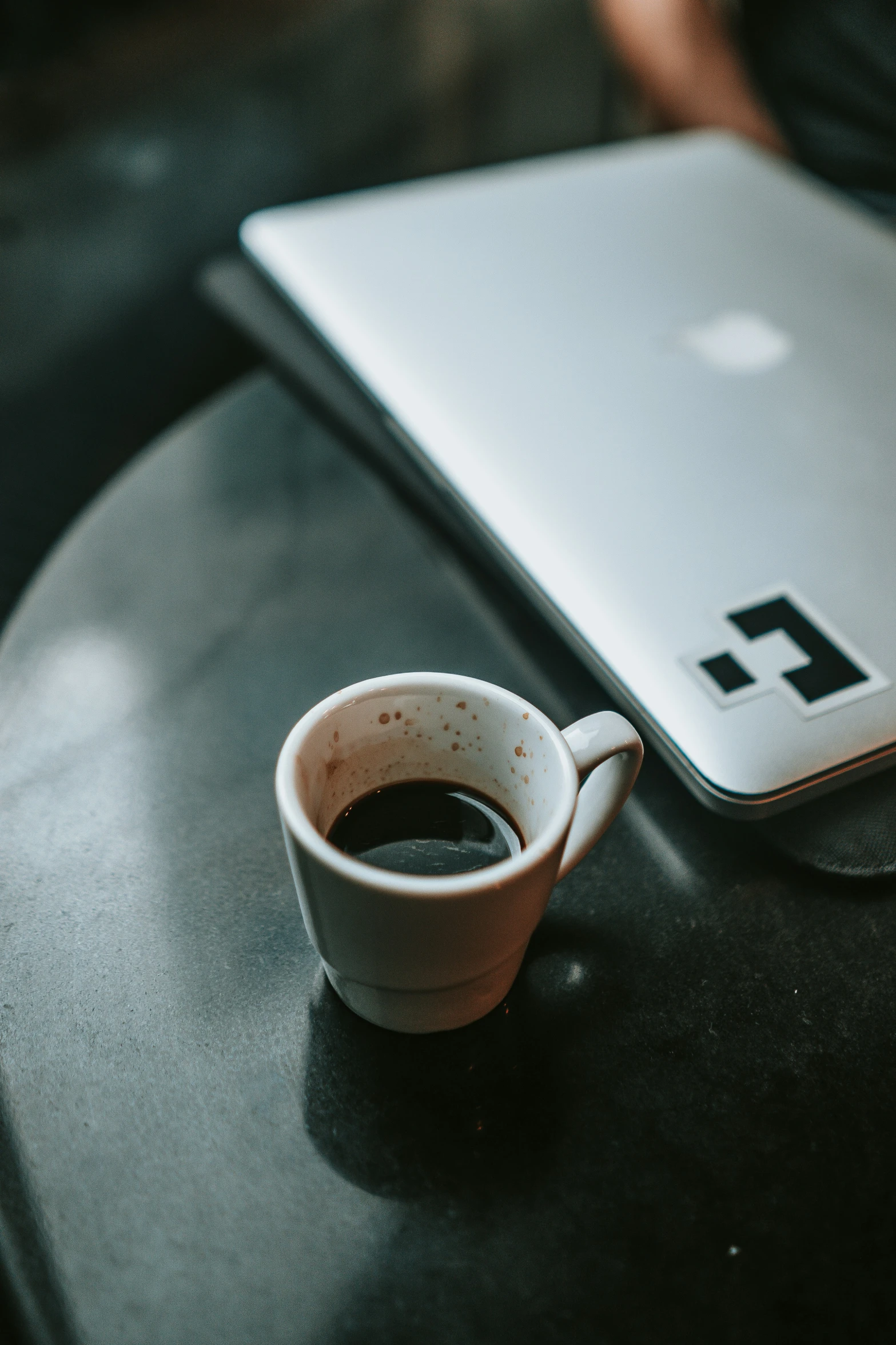 a cup of coffee next to a laptop