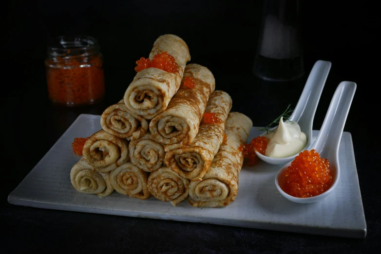 many breads on a plate, next to dipping sauce