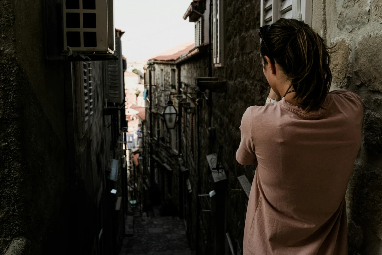 a woman looking at the city street from behind