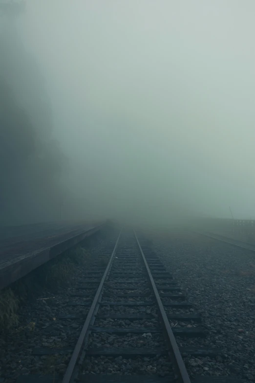 train tracks on a railroad in the fog