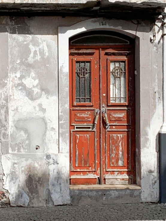 an old building with two open red doors