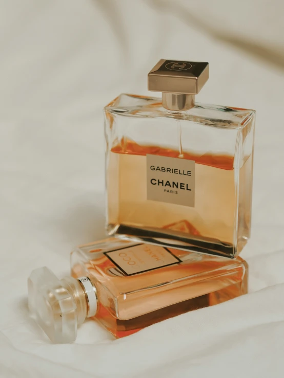 two bottles of chanel perfumes sitting on a white table