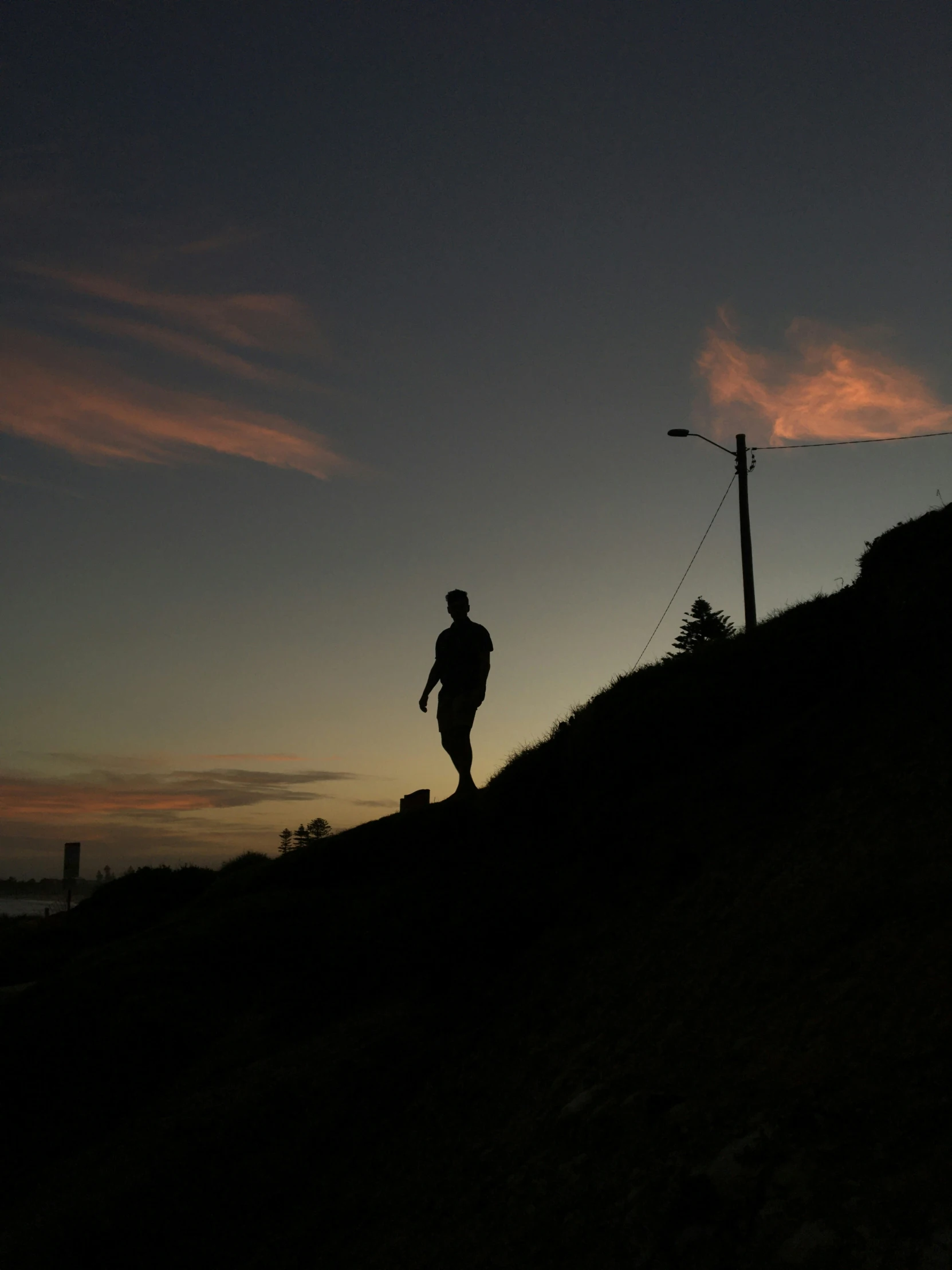 a person walking across the grass on a hill