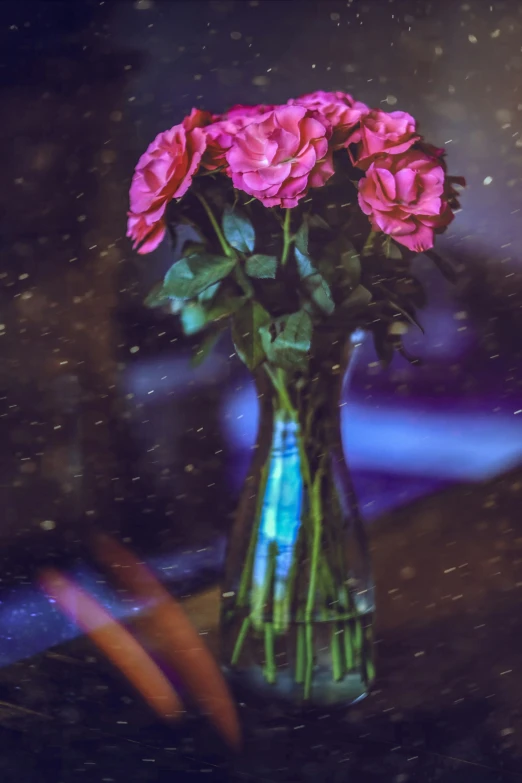 a vase filled with pink roses sitting on a table