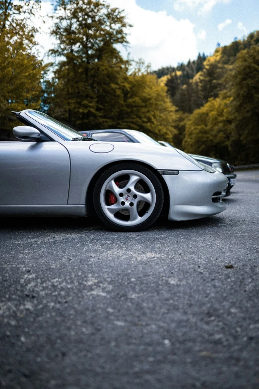 a white sports car parked in front of some trees