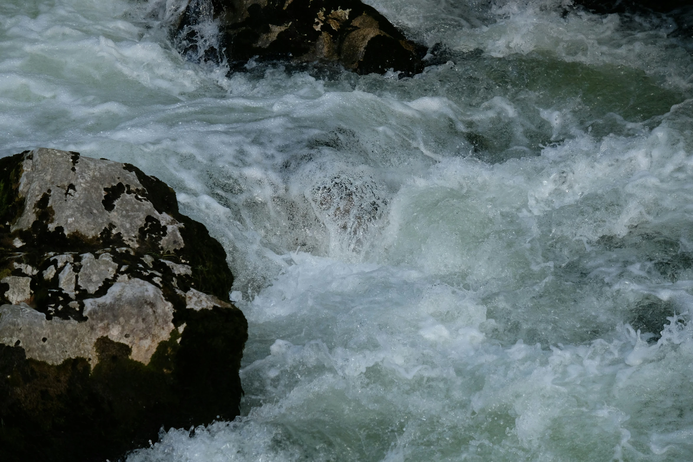 a big rock in the middle of some water