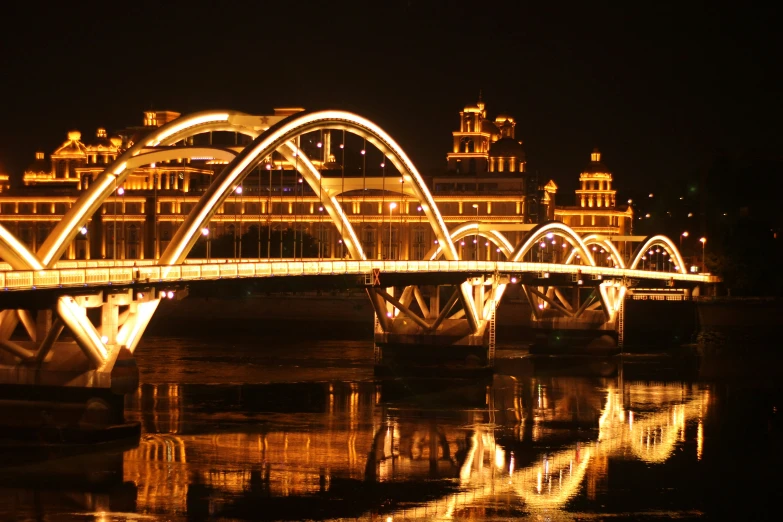 a bridge with a very long line of lights that have buildings in the background