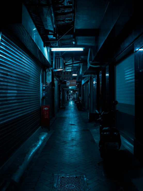 a dark alley way with storage doors lit by street lights