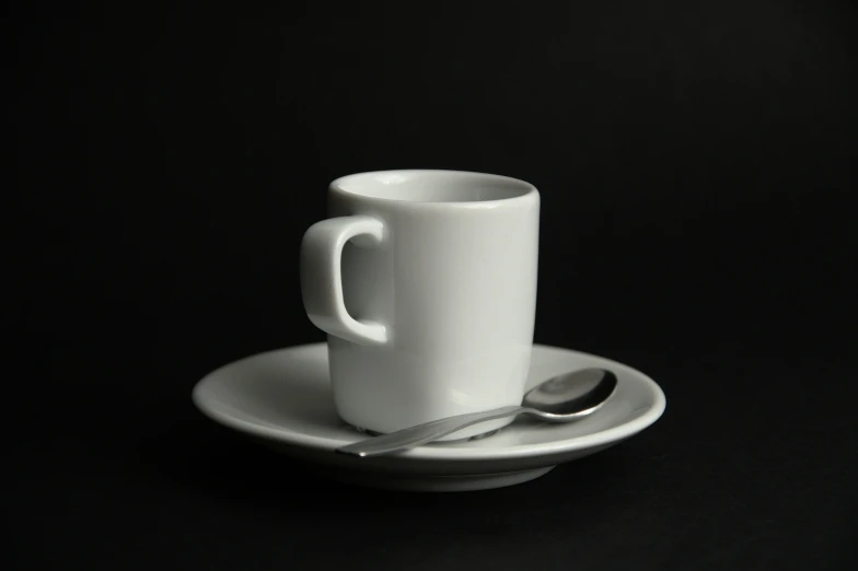 a cup and saucer sit on a black table