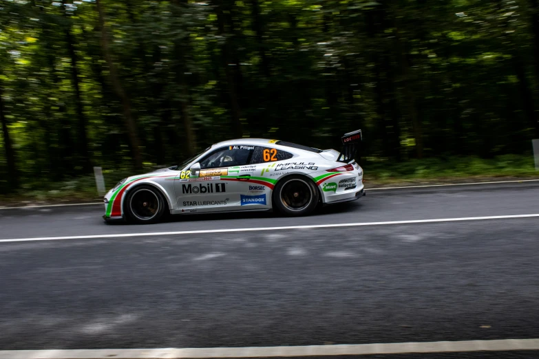 a porsche racing car with trees in the background