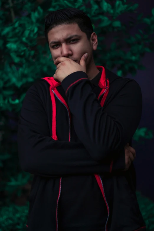 a man in black and red hoodie posing for a picture