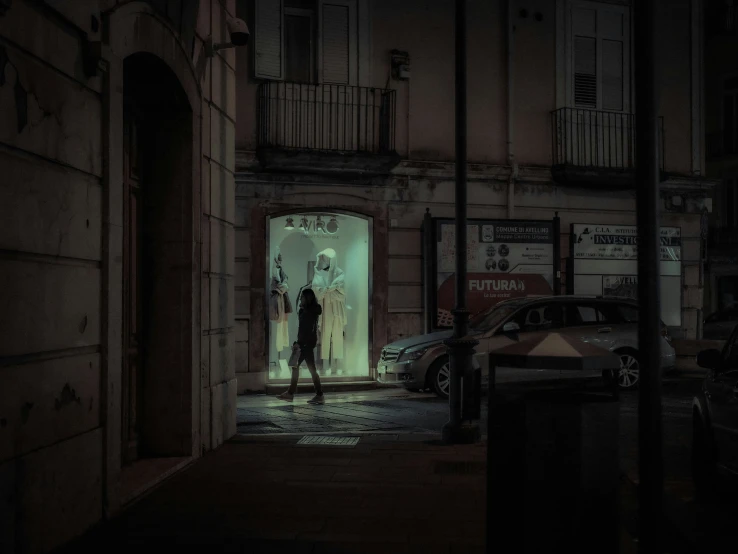 a couple of people standing in an archway at night