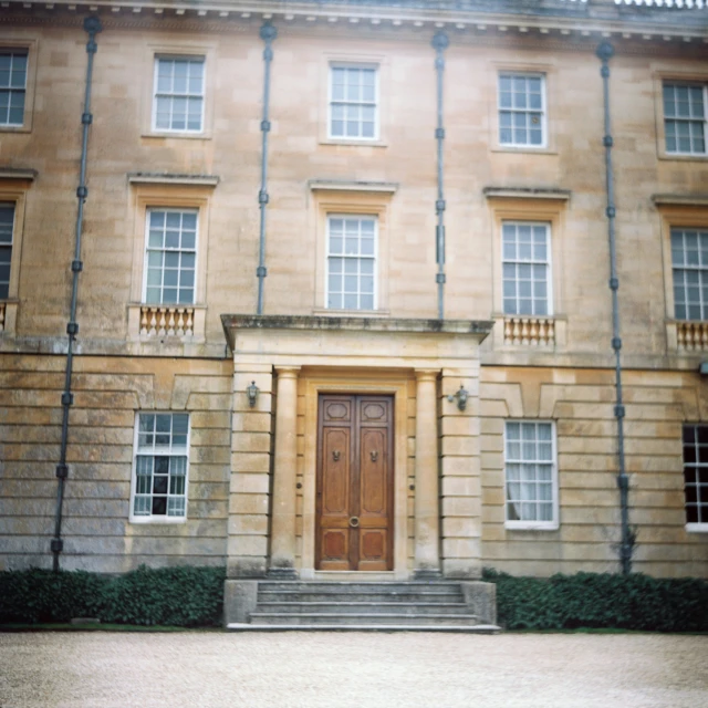 two brown doors with white windows and an entrance