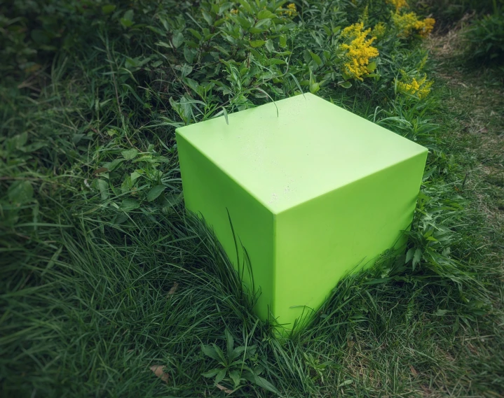 an outdoor display of a green sculpture in the grass