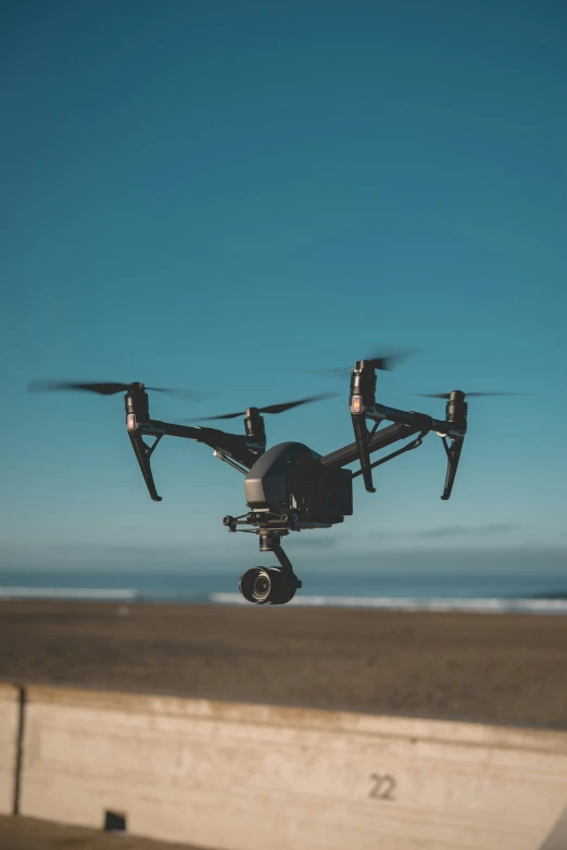 a large black device flying through the air near a wall