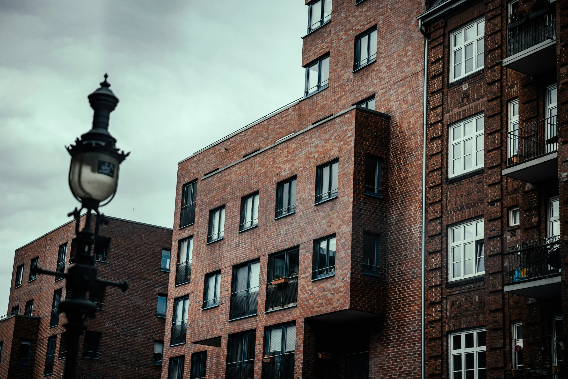 a street light sitting between two buildings on a cloudy day