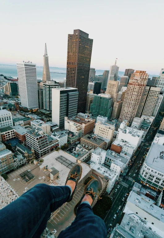 the legs and ankles of a person standing on top of a building