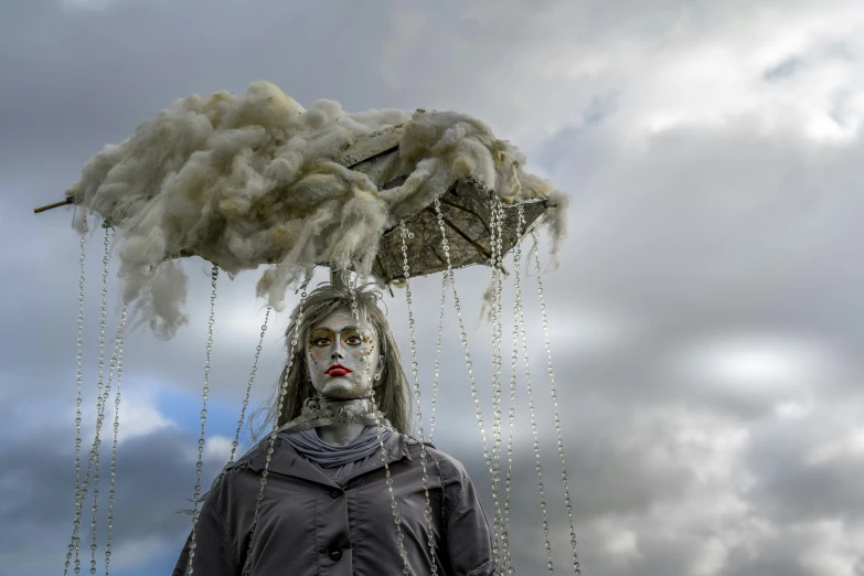 a statue with a white mask on, holding a black umbrella