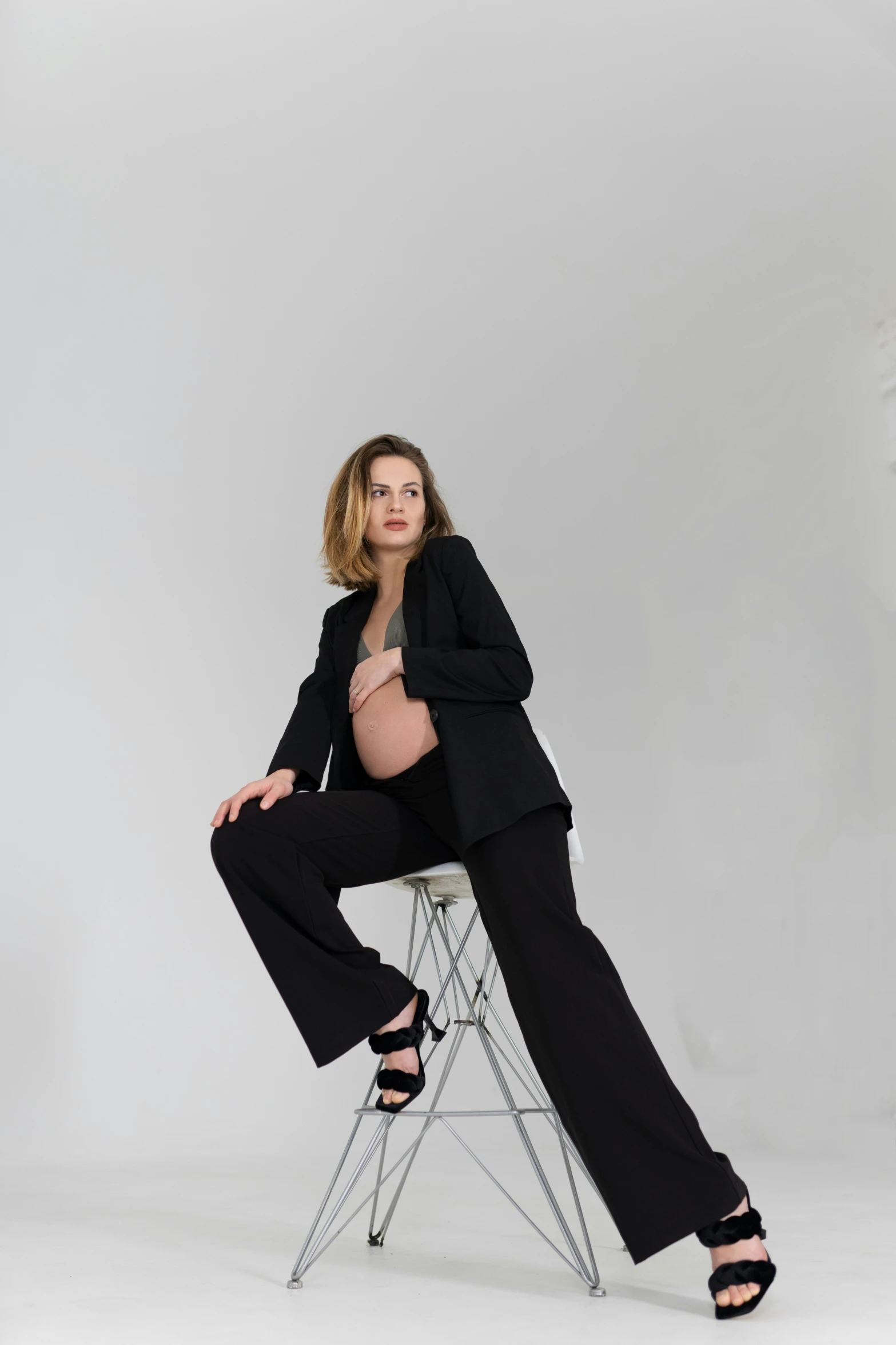 a woman sitting on a chair, posing for a po