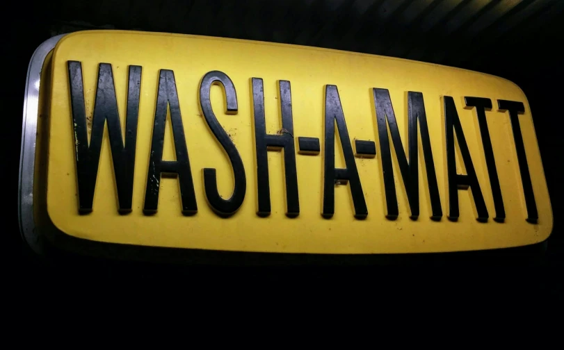 there is a sign that says washhamatt in black on a yellow background