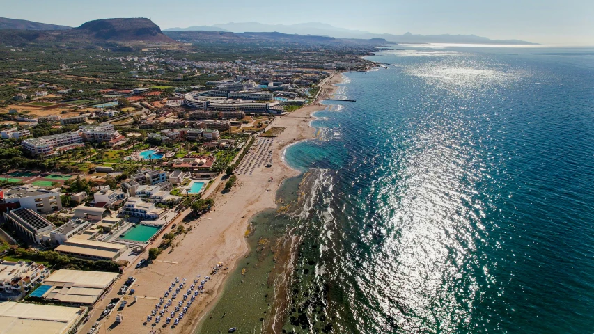 an aerial view of the coast line with a beach on one side and buildings on another