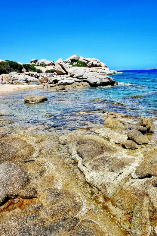 the water is calm and clear near the rocky shore