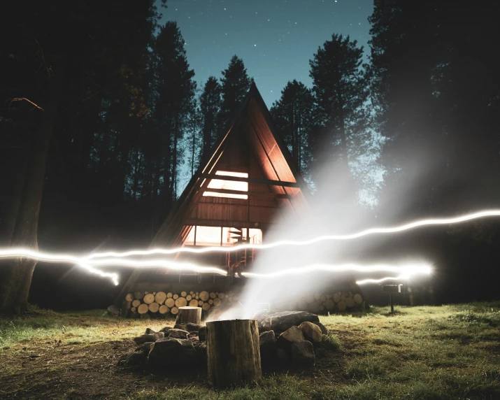 a lit fire in front of a cabin