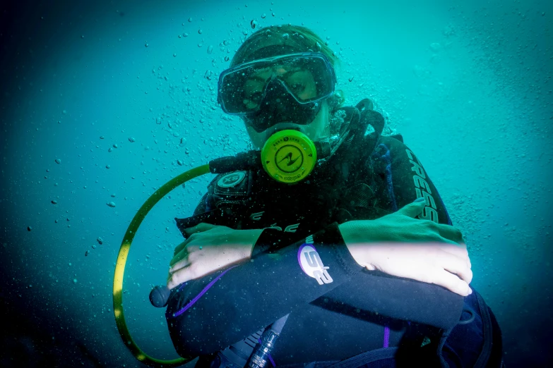 a person swimming in the ocean wearing a scuba helmet