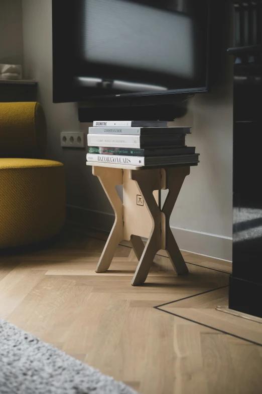 a stack of books are sitting on a table in front of a television