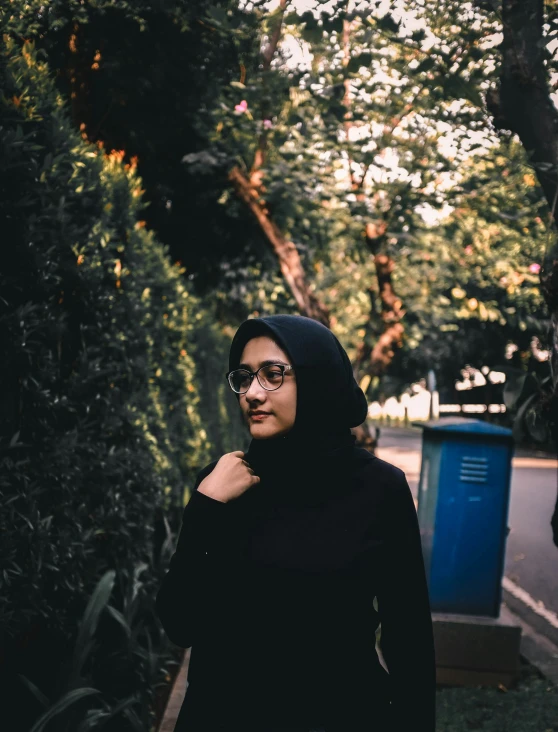 a woman wearing glasses and a black outfit in a park