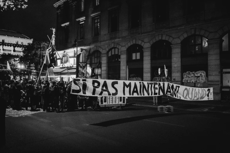 a group of people holding signs in front of a building