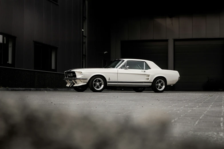 a white ford mustang sitting in the street