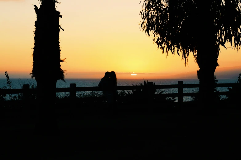 a couple sitting in the back of a car on a bench