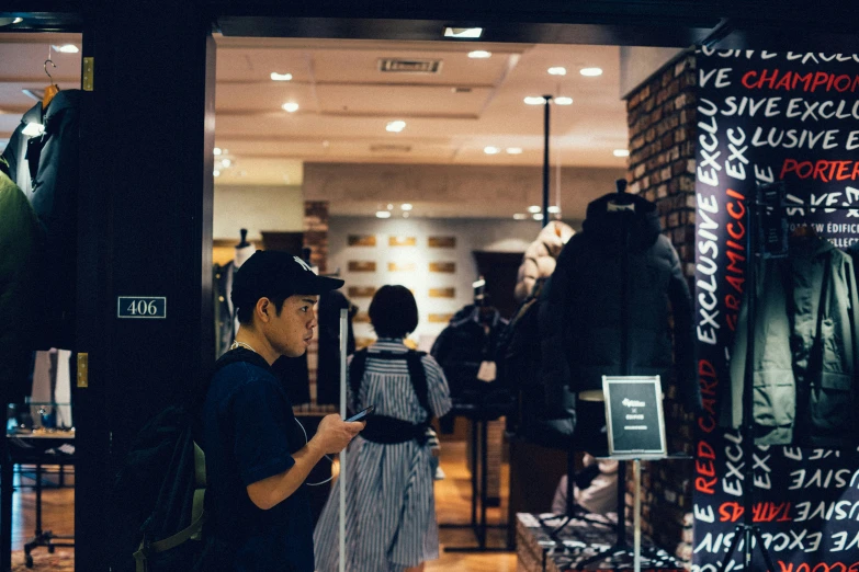 a man holding onto an umbrella in front of a clothing store