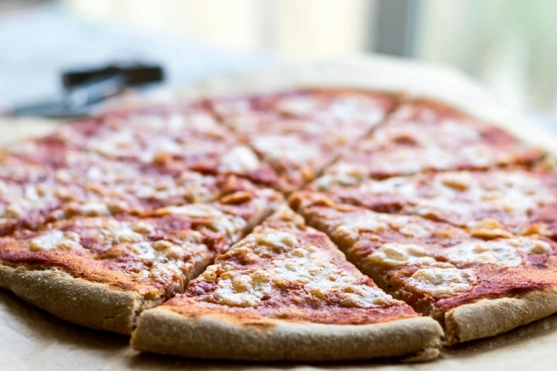 a whole pizza is on the table with a remote control