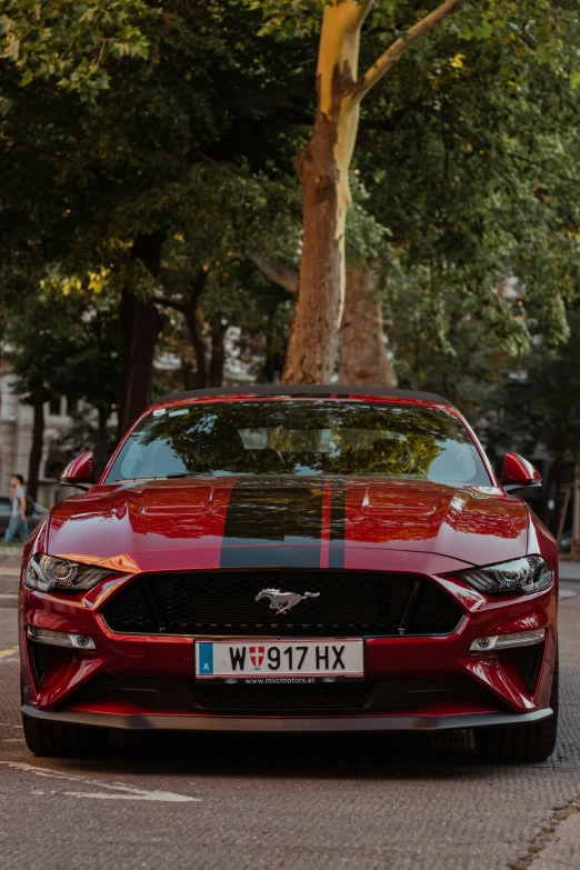 a red mustang mustang parked on the street